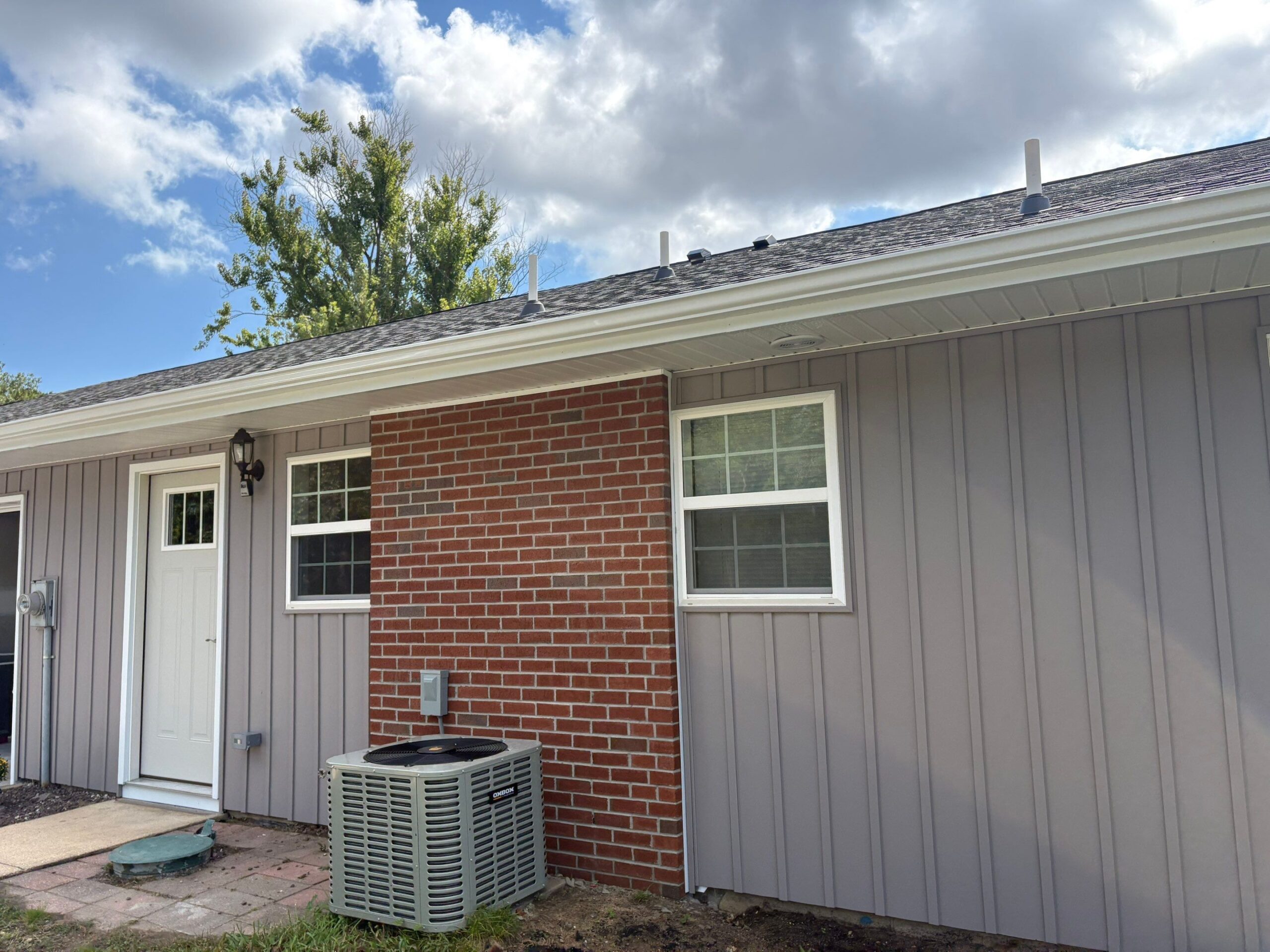Complete fire restoration exterior showing new HVAC system brick accent vinyl siding windows in Leisure Village Lakewood NJ 08701 by Toms River Restoration